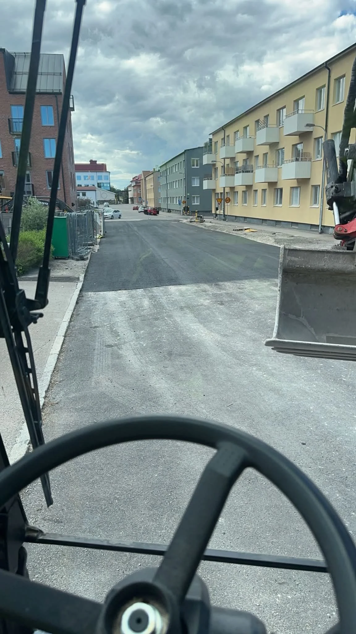 Färdig asfalterad gata mellan byggnader