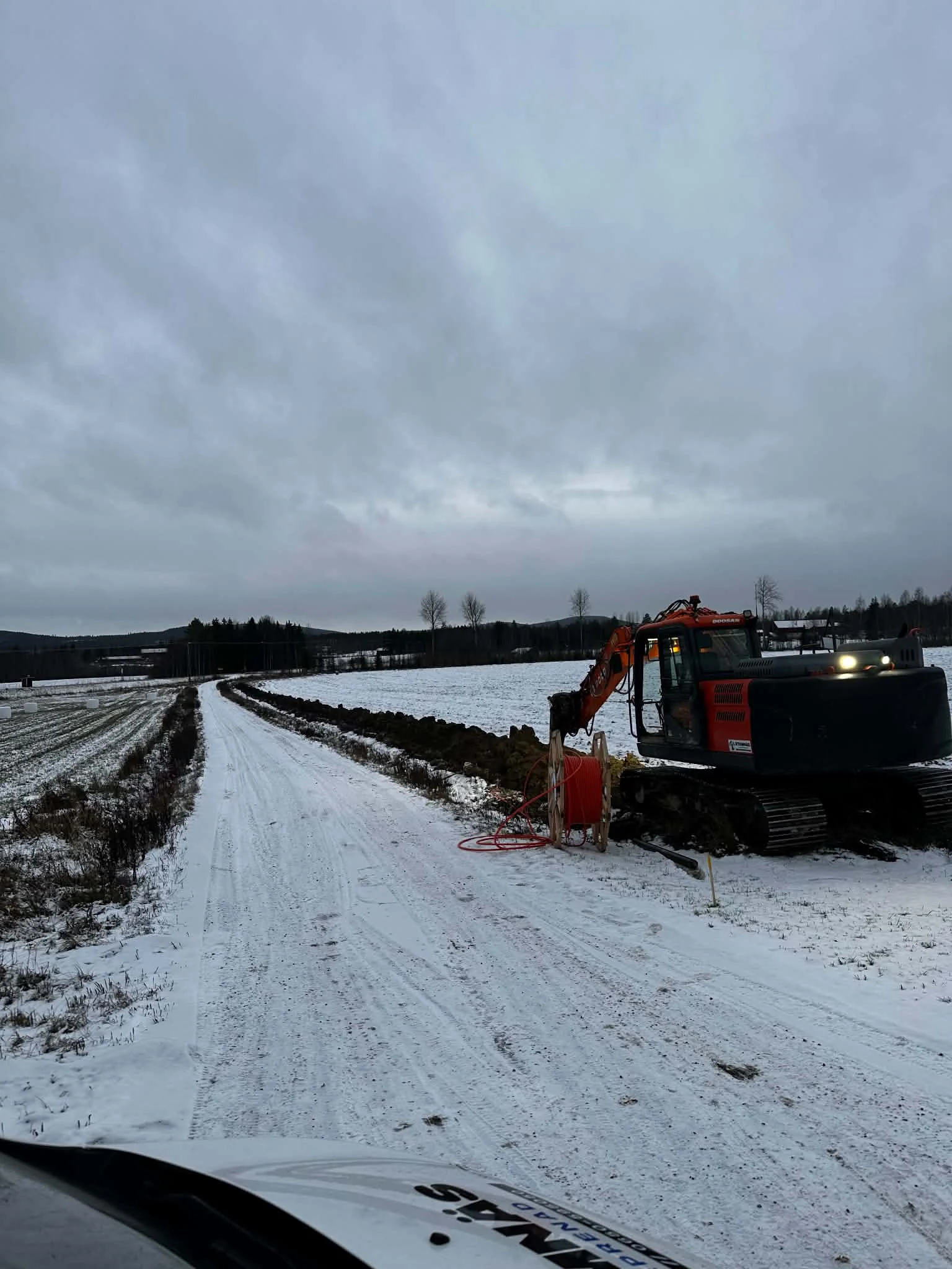 Grävmaskin arbetar i en öppen schakt under vinterförhållanden