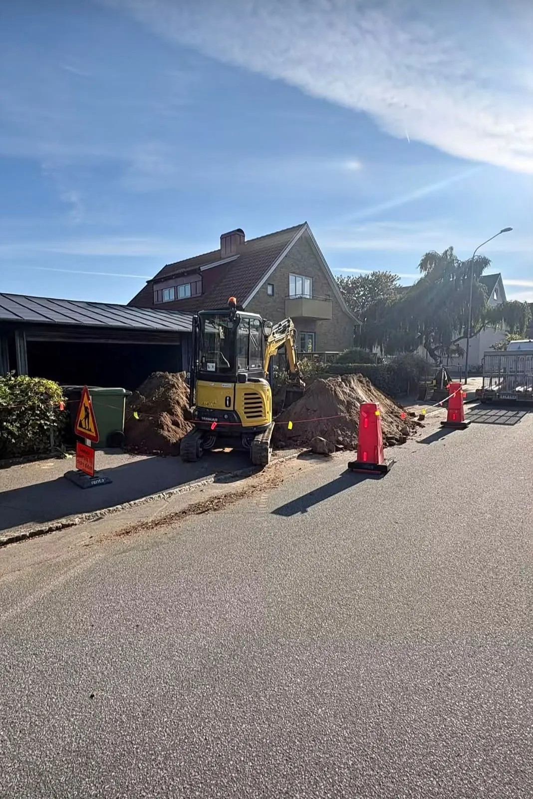 Grävmaskin på avspärrad villagata