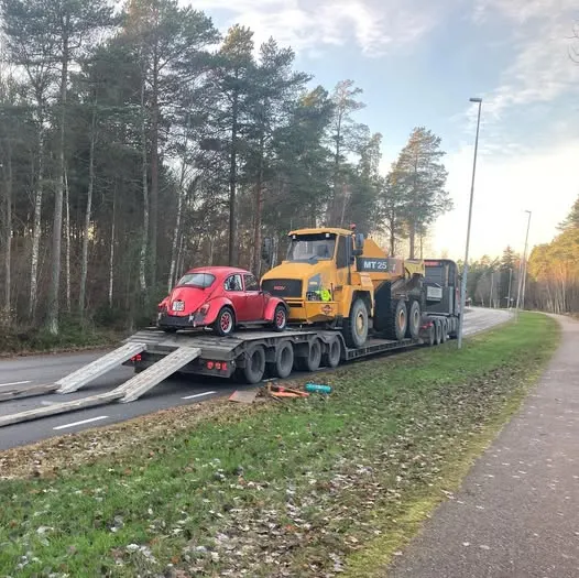 Dumper på en maskintrailer längs en gata